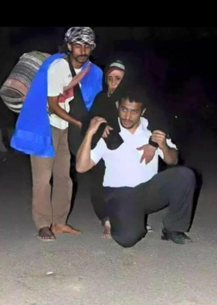 بالصورة .. موظف في منفذ الوديعة يحمل مسنة يمنية على ظهره
