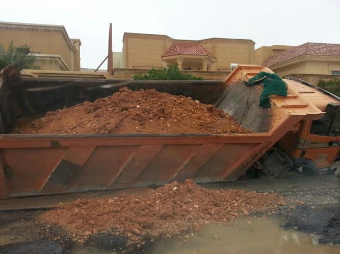 بالصور.. الأمطار تكشف تهالك شارع سقطت به شاحنة في الرياض