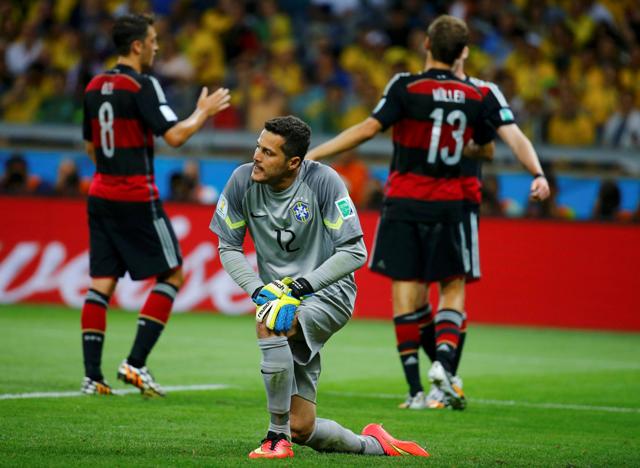 Brazil's goalkeeper Julio Cesar (12) reacts as Germany's Andre Schuerrle (rear R, obscured) celebrates with teammates Mesut Ozil (L) and Thomas Mueller (R) after scoring the team's sixth goal during their 2014 World Cup semi-finals at the Mineirao stadium in Belo Horizonte July 8, 2014. REUTERS/Kai Pfaffenbach (BRAZIL - Tags: SOCCER SPORT WORLD CUP)