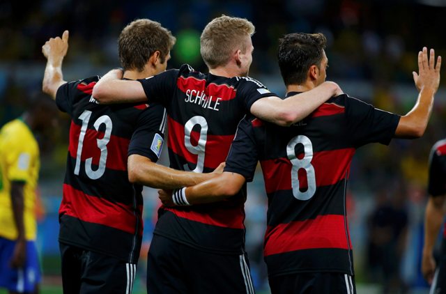 Germany's Andre Schuerrle (C) celebrates scoring his team's sixth goal against Brazil with teammates Dante (L) and Paulinho during their 2014 World Cup semi-finals at the Mineirao stadium in Belo Horizonte July 8, 2014. REUTERS/Damir Sagolj (BRAZIL - Tags: SOCCER SPORT WORLD CUP)