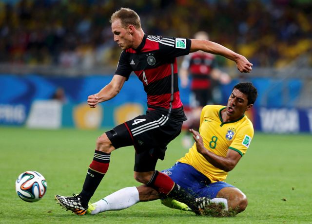 Germany's Benedikt Hoewedes fights for the ball with Brazil's Paulinho during their 2014 World Cup semi-finals at the Mineirao stadium in Belo Horizonte July 8, 2014. REUTERS/Marcos Brindicci (BRAZIL - Tags: SOCCER SPORT WORLD CUP)