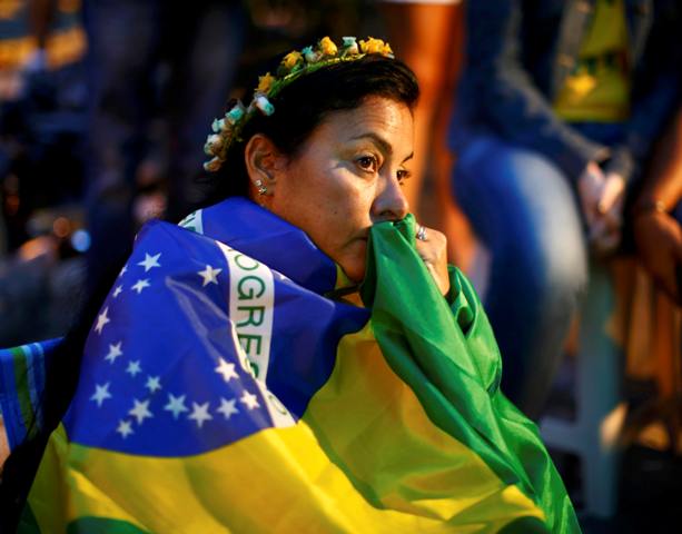 Brazil fans react as they watch their 2014 World Cup semi-finals against Germany on a street in Rio de Janeiro July 8, 2014. REUTERS/Jorge Silva (BRAZIL - Tags: SOCCER SPORT WORLD CUP)
