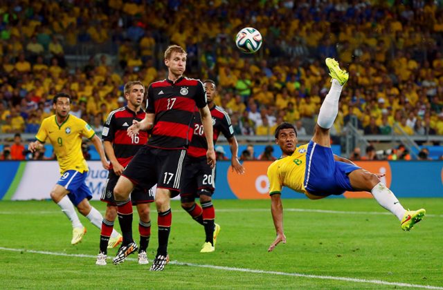 Brazil's Paulinho (R) attempts an overhead kick against Germany during their 2014 World Cup semi-finals at the Mineirao stadium in Belo Horizonte July 8, 2014. REUTERS/Eddie Keogh (BRAZIL - Tags: SOCCER SPORT WORLD CUP)