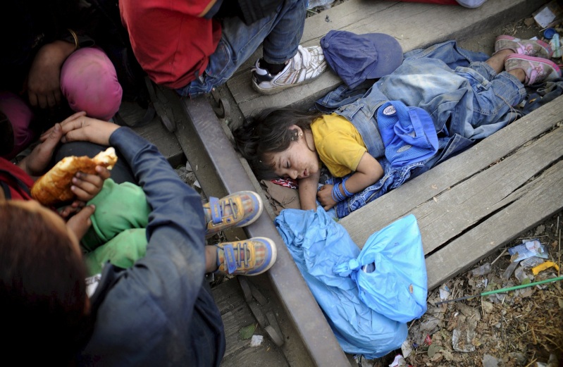 Four-year-old Rashida from Kobani, Syria, part of a new group of more than a thousand immigrants, sleeps as they wait at border line of Macedonia and Greece to enter into Macedonia near Gevgelija railway station August 20, 2015.  REUTERS/Ognen Teofilovski   SEARCH "YEAREND 2015: MIGRANT CRISIS" FOR ALL 55 PICTURES      TPX IMAGES OF THE DAY