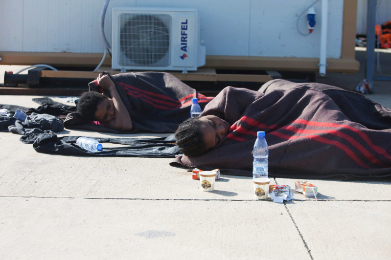 Illegal migrants lay in a navy base, after a boat sank off the coast, in Tripoli, December 21, 2015.. REUTERS/Hani Amara