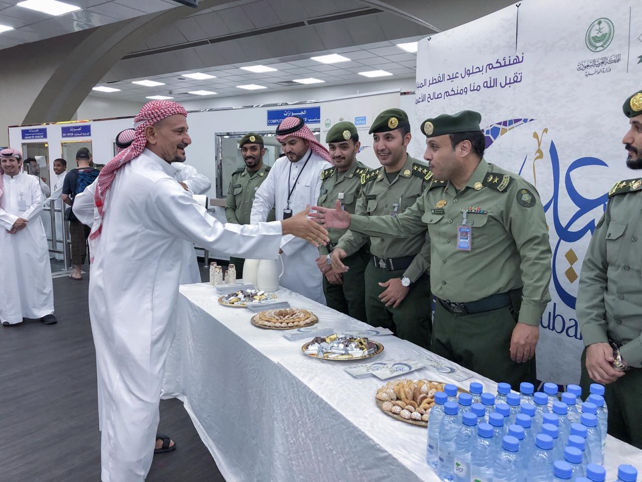 شاهد بالصور.. جوازات مطار الملك عبدالعزيز تعايد المسافرين بالحلوى والهدايا