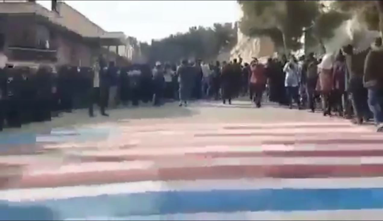 صور.. متظاهرون إيرانيون يرفضون السير فوق العلم الأمريكي