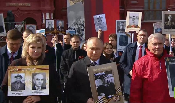 شاهد.. بوتين يحمل صورة والده في مسيرة الفوج الخالد