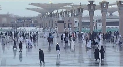 زوار المسجد النبوي يبتهلون بالدعاء تحت زخات المطر