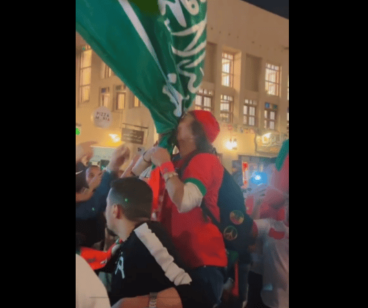 مشجع مغربي يُقبّل علم السعودية أثناء احتفاله