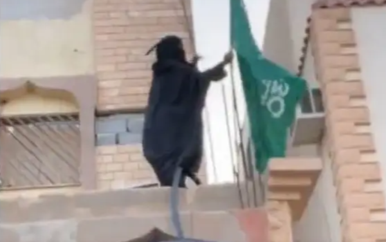 مُسنة تغامر وتتسلق منزلها لرفع العلم السعودي: عاش الوطن