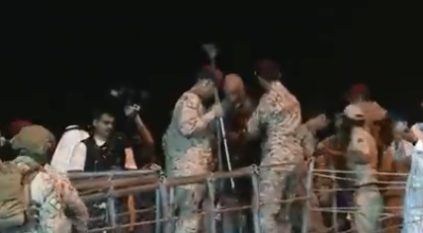 منسوبو الدفاع يساعدون مسنًّا في النزول من على السفينة ضمن الإجلاء