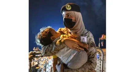 الجارديان تختار لقطة مجندة سعودية تحمل طفلاً كأفضل صورة