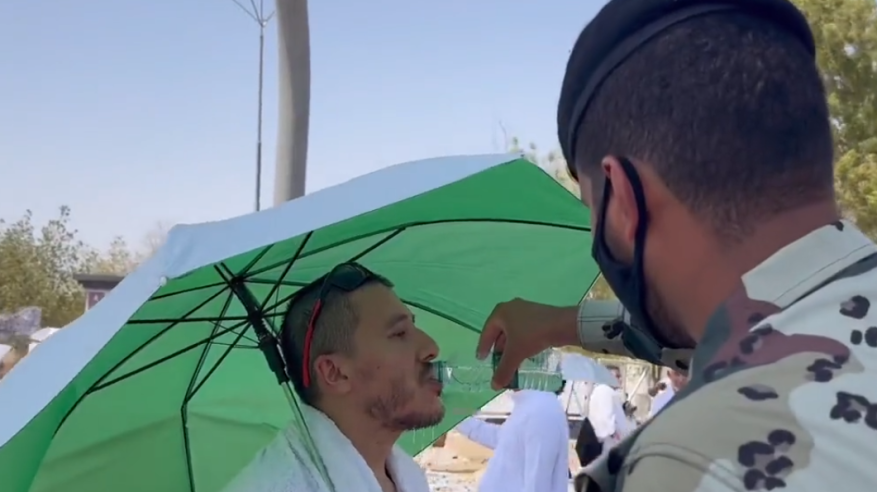رجل أمن يخفف حرارة الجو عن ضيوف الرحمن