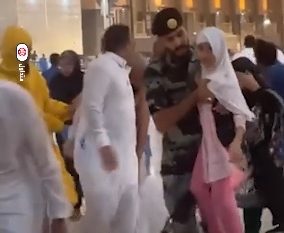 لقطة إنسانية لجندي بالحرم المكي يحمي طفلة من الرياح