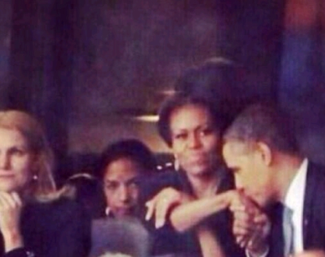 بالصور.. سيدة تُثير غَيرة زوجة أوباما خلال تأبين مانديلا