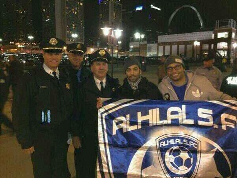 صورة.. مشجع سعودي يحمل مع أفراد الشرطة في أمريكا شعار الهلال
