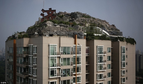بالصور… صيني يبني جبلاً وسطه فيلا فوق بناية سكنية