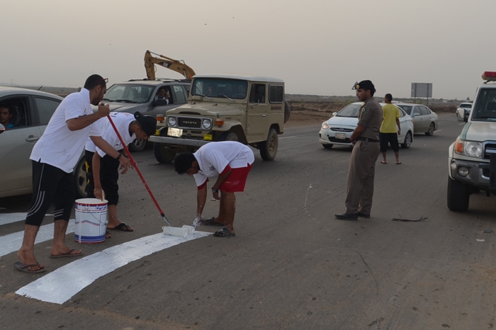 بالصور ..متطوعون يخططون المطبات بالطريق الرئيسي بجازان