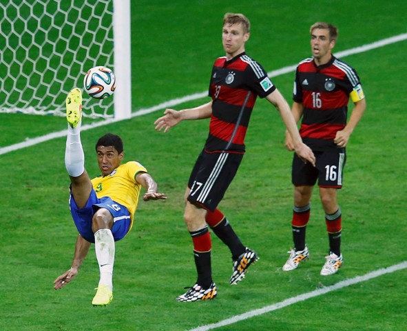 Brazil's Paulinho (L) performs a scissors kick past Germany's Philipp Lahm (R) and Per Mertesacker during their 2014 World Cup semi-finals at the Mineirao stadium in Belo Horizonte July 8, 2014. REUTERS/Leonhard Foeger (BRAZIL - Tags: SOCCER SPORT WORLD CUP)
