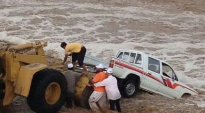 بالصور .. إنقاذ مسن وسائقه من سيل وادي الحناء