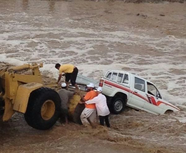 بالصور .. إنقاذ مسن وسائقه من سيل وادي الحناء