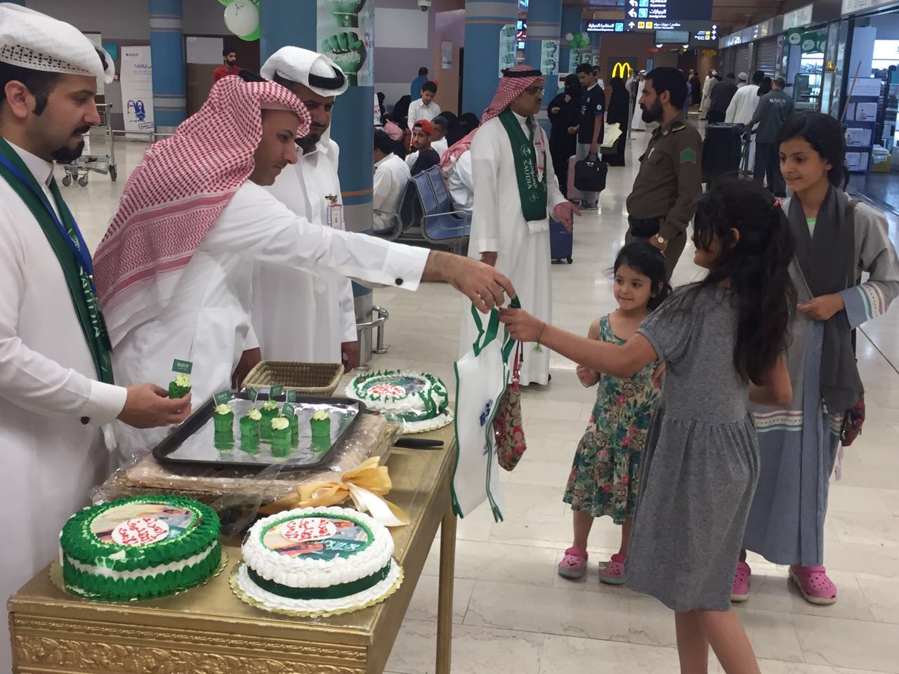 بالصور.. بالهدايا والأعلام مطار أبها يحتفل مع المسافرين باليوم الوطني 87