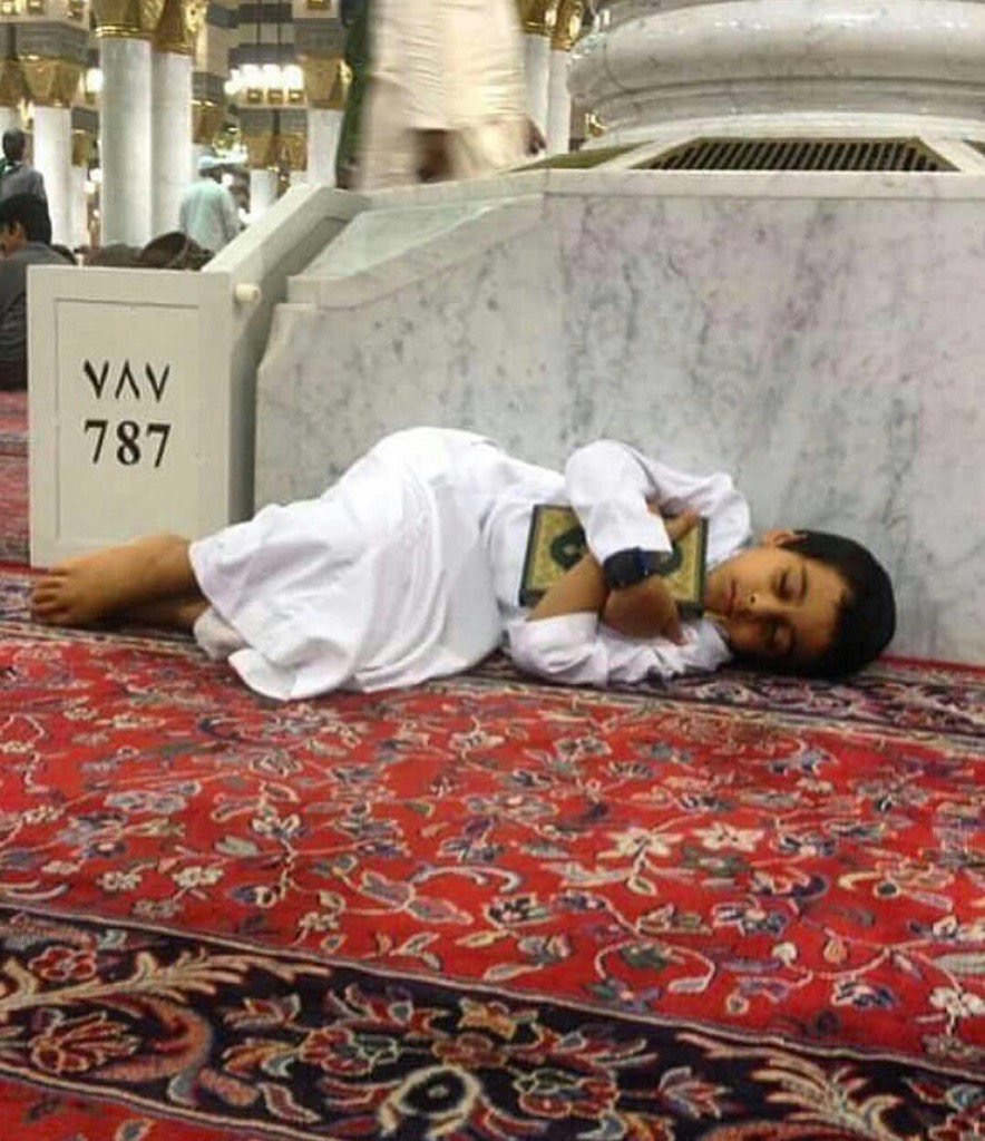صورة مؤثرة.. طفل نائم وهو يحتضن القرآن الكريم