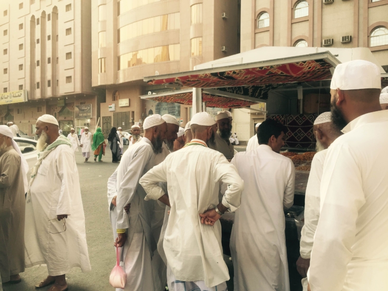 صورة توضح عدد من الحجاج يقومون بشراء بعض الهدايا 