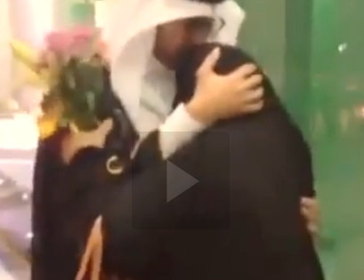 شاهد بالفيديو..سعودية تنتظر ابنها عند بوابة الجامعة بالورود