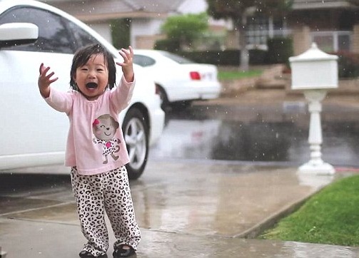 بالصور … إنبهار طفلة ترى الأمطار لأول مرة