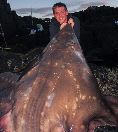 بالصور.. صياد شاب يصطاد أكبر سمكة في بريطانيا