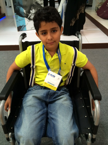 أصغر طفل يجرب لأول مرة الكرسي المتحرك في معرض الصحة