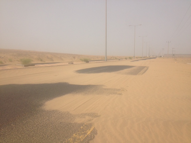بالصور.. الرمال تطمس معالم الطريق الرئيسي المؤدي لدوقة الأولى