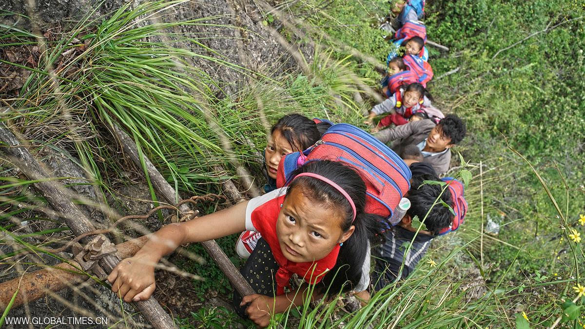 بالصور.. أطفال يخاطرون بحياتهم يومياً للذهاب إلى المدرسة في جبال الصين