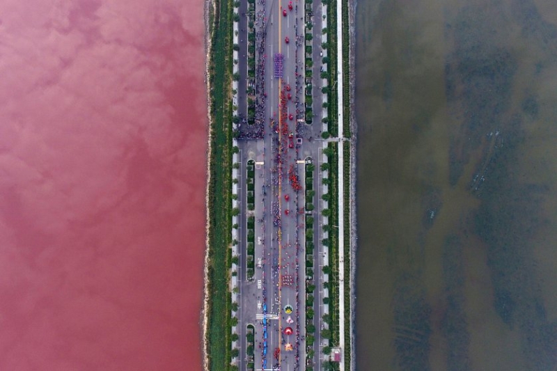A salt lake which is separated by a road, shows parts of it in different colors due to algae, in Yuncheng, Shanxi Province, China, on Sept. 25, 2016.