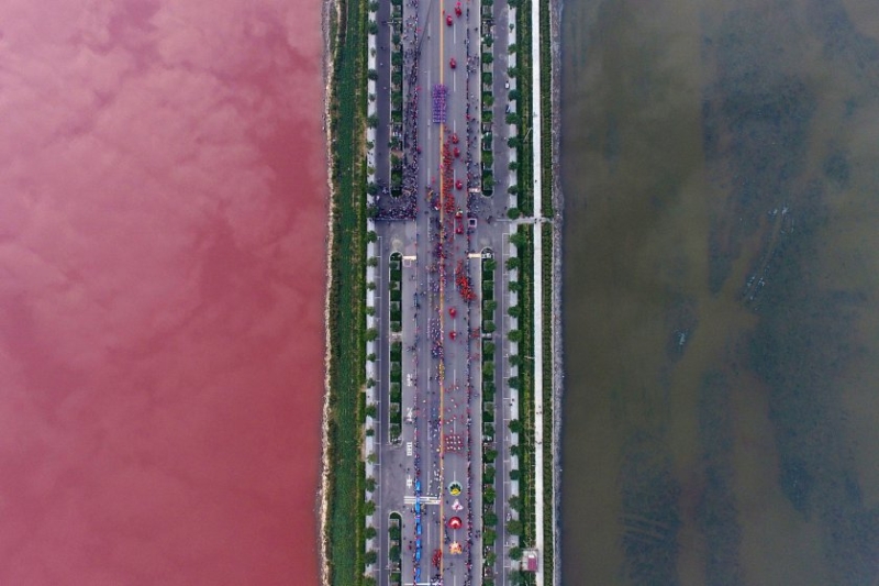 A salt lake which is separated by a road, shows parts of it in different colors due to algae, in Yuncheng, Shanxi Province, China, on Sept. 25, 2016.