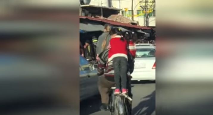 بالفيديو.. أب ينقل أولاده بالدرّاجة على الطريقة الهندية