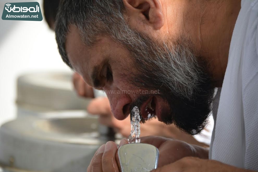 شاهد بالصور .. الحجاج يروون عطشهم ويبردون أجسادهم في الطريق إلى منى