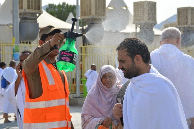 الحجاج يروون عطشهم ويبردون أجسادهم في الطريق إلى منى ‫(332918082)‬ ‫‬