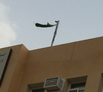 العلم السعودي ممزقاً على مبنى ثانوية في المجاردة ‫(1)‬