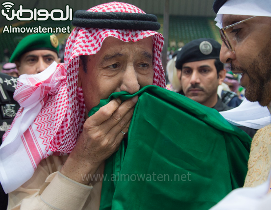 شاهد بالصور.. الملك يقبّل علم المملكة في حفل العرضة السعودية