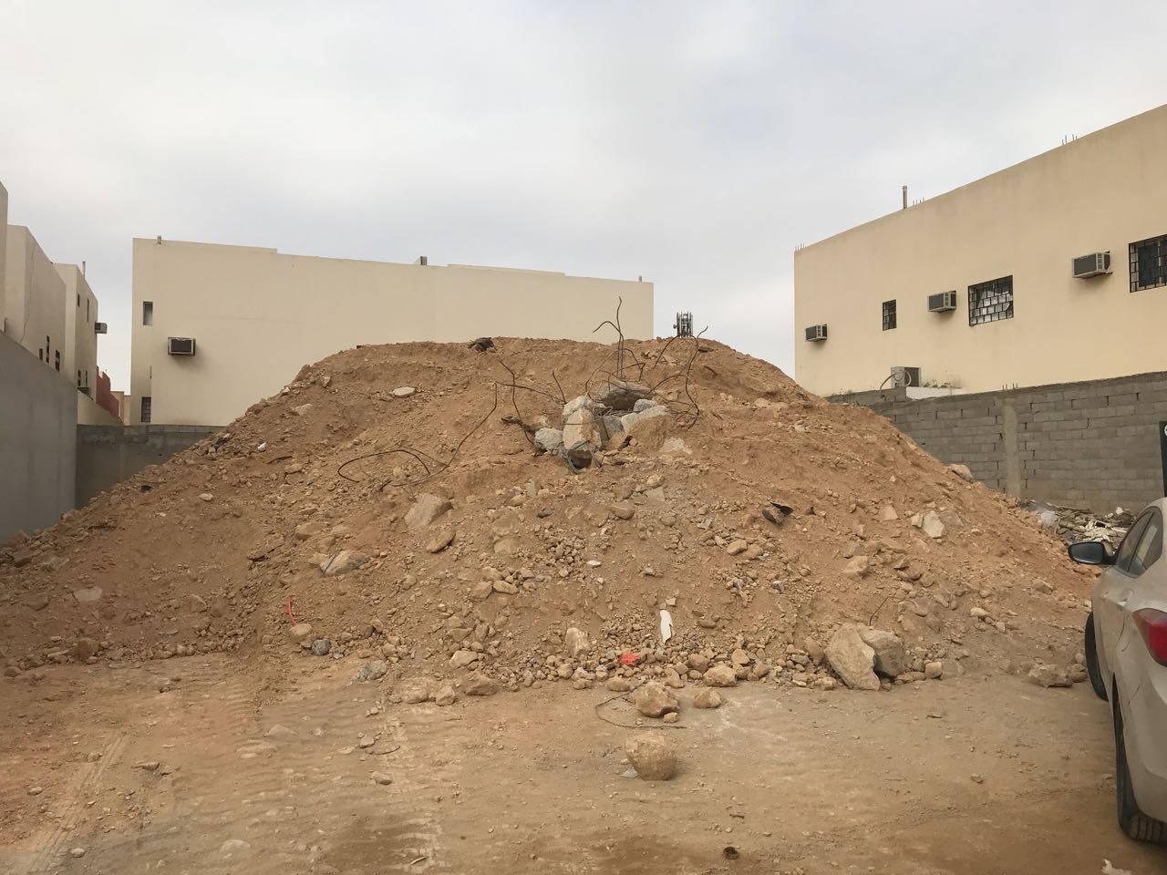 بالصور.. تلال التراب تحاصر منزل مواطن في الرياض