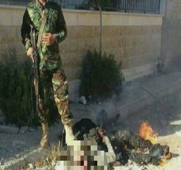 سوريا.. عنصر من حزب الله يحرق جثة ويتصور معها