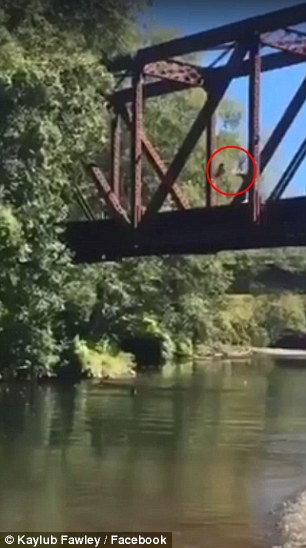 شاهد.. رجل يلقي طفلًا من أعلى جسر للسكك الحديدية!