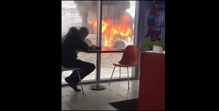 روسي يتناول الغداء بهدوء على بعد أمتار من سيارة تحترق