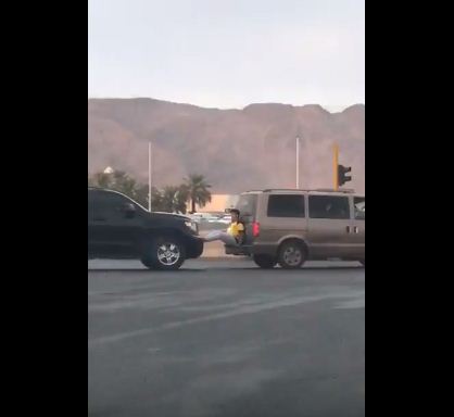 بالفيديو.. شاب يعرض حياته للخطر بالجلوس بين سيارتين متحركتين