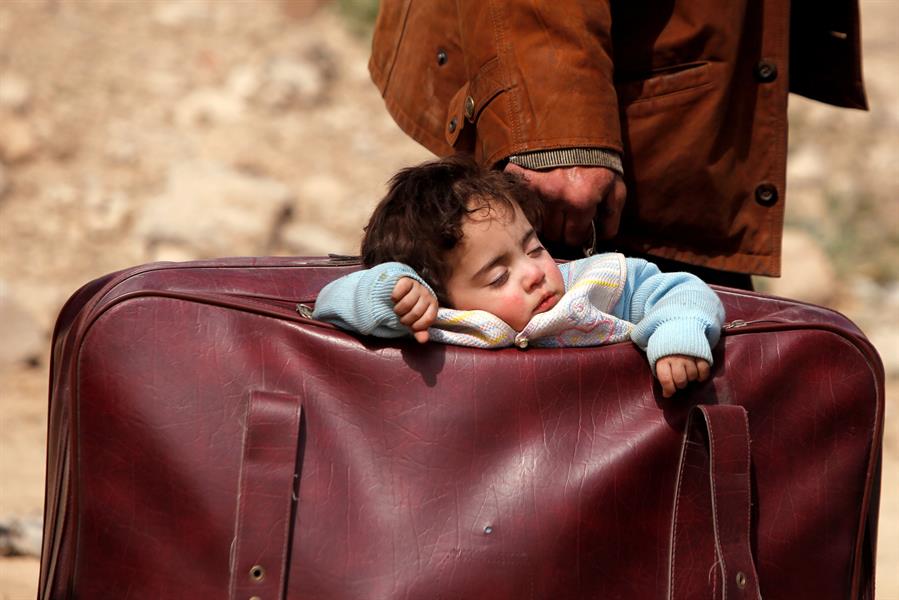 صورة مؤثرة لطفلة من الغوطة تنام داخل حقيبة والدها أثناء نزوحه