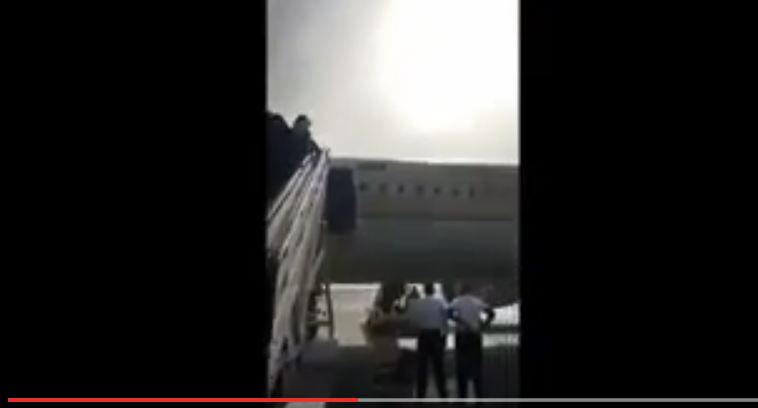 شاهد.. طيار ومساعده يصلّيان تحت سلم الطائرة قبل إقلاعها