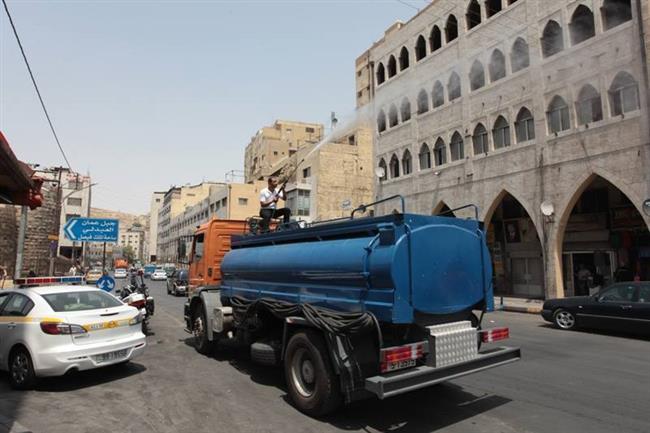 رشّ الشوارع بالماء لتخفيف الحرارة في الأردن